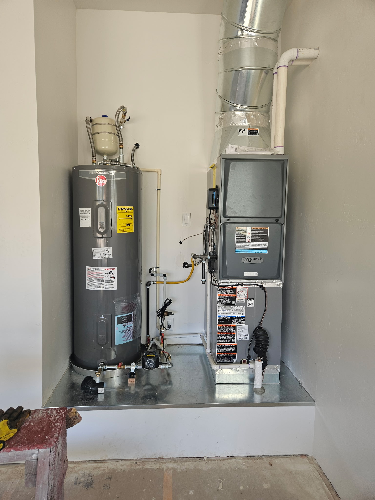 Furnace and water heater installed side by side in a clean finished mechanical room